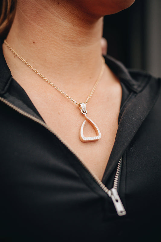 Yellow gold Jump Stirrup Pendant, set with 1/2 carat of round brilliant cut white diamonds. Paired beautifully with a yellow gold calbe chain. 