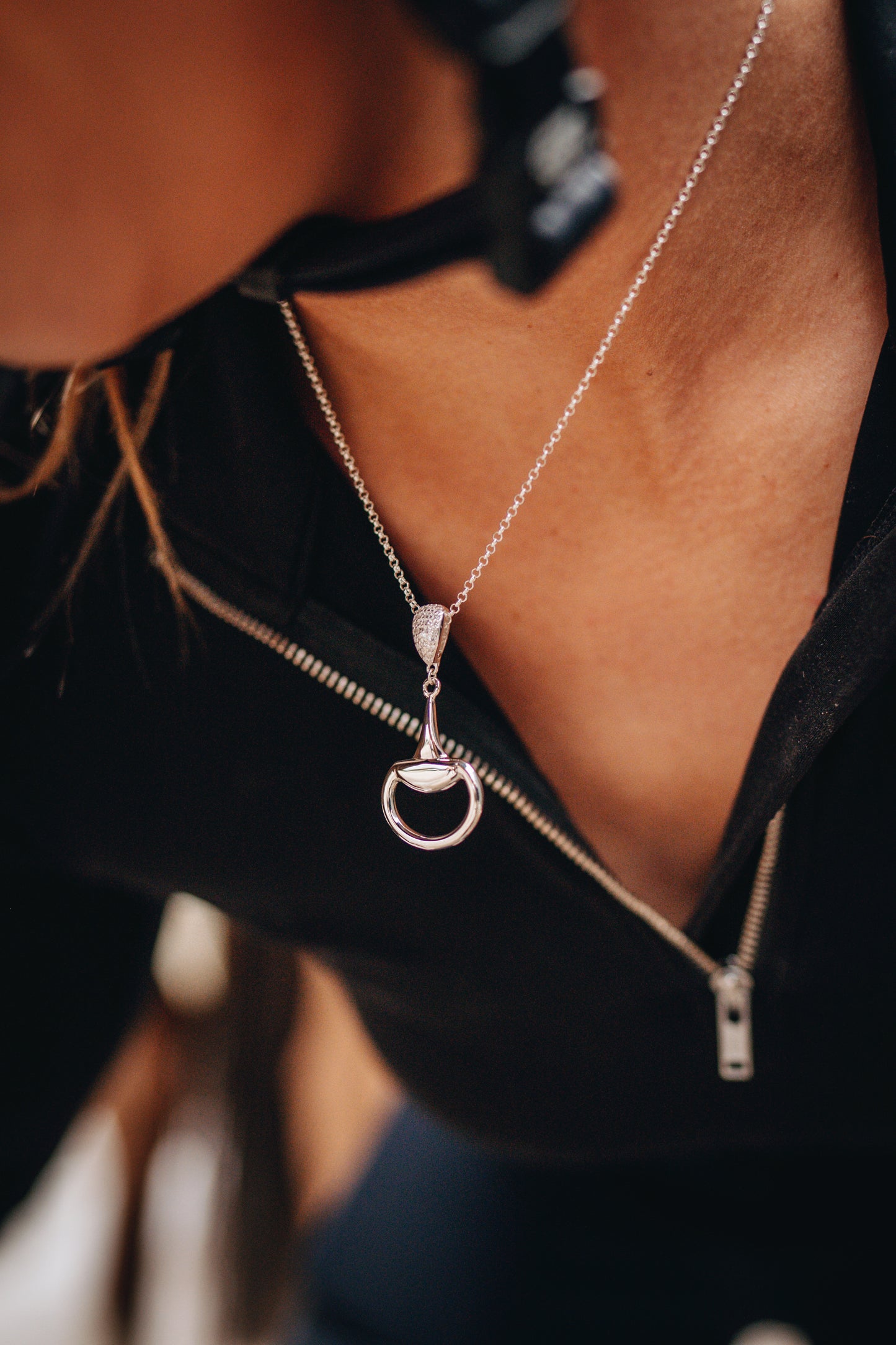 An equestrian horse rider ready to mount wearing a sterling silver Bling Half Snaffle Pendant. Made by Crawford Hill Equestrian Jewellery.
