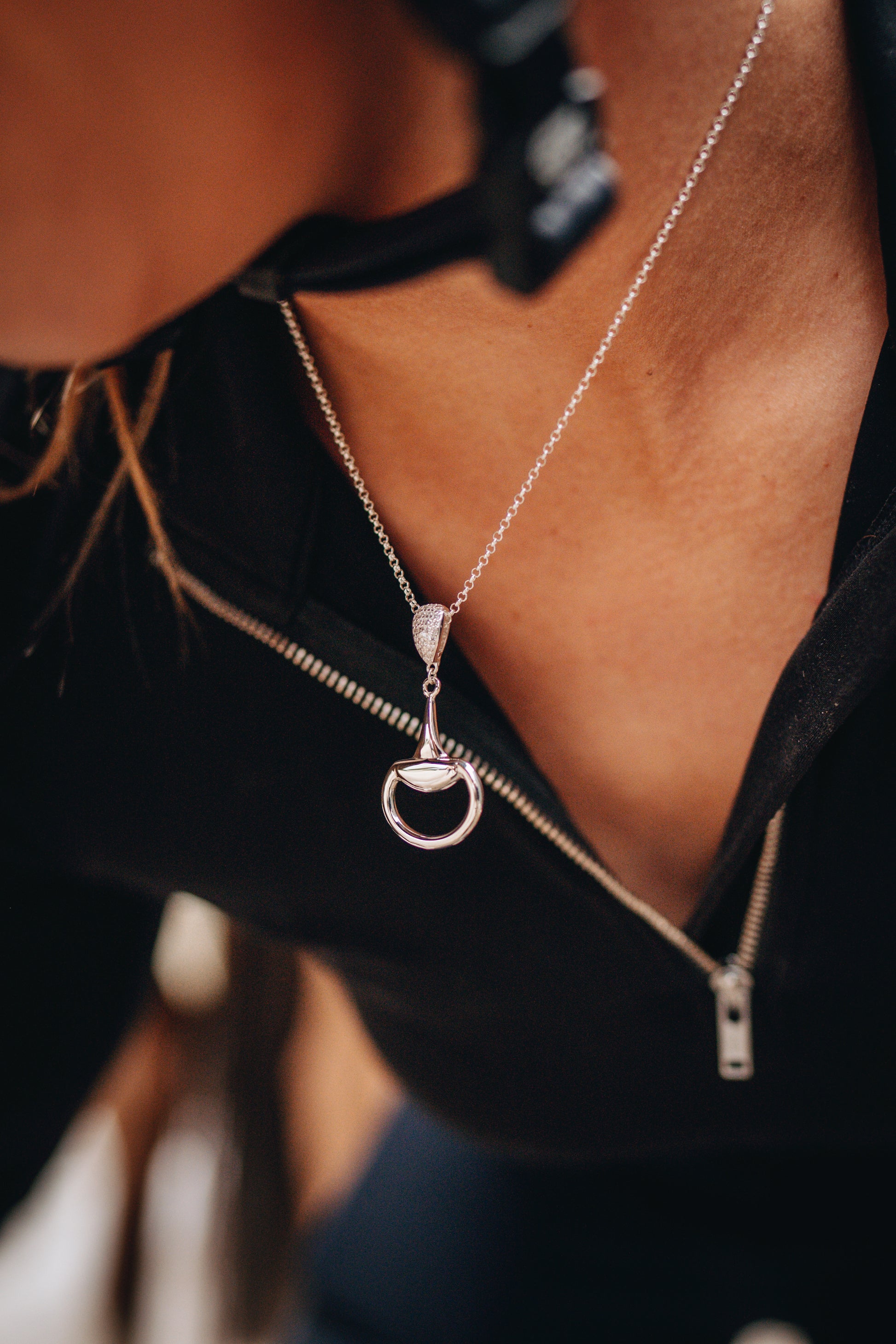 An equestrian horse rider ready to mount wearing a sterling silver Bling Half Snaffle Pendant. Made by Crawford Hill Equestrian Jewellery.
