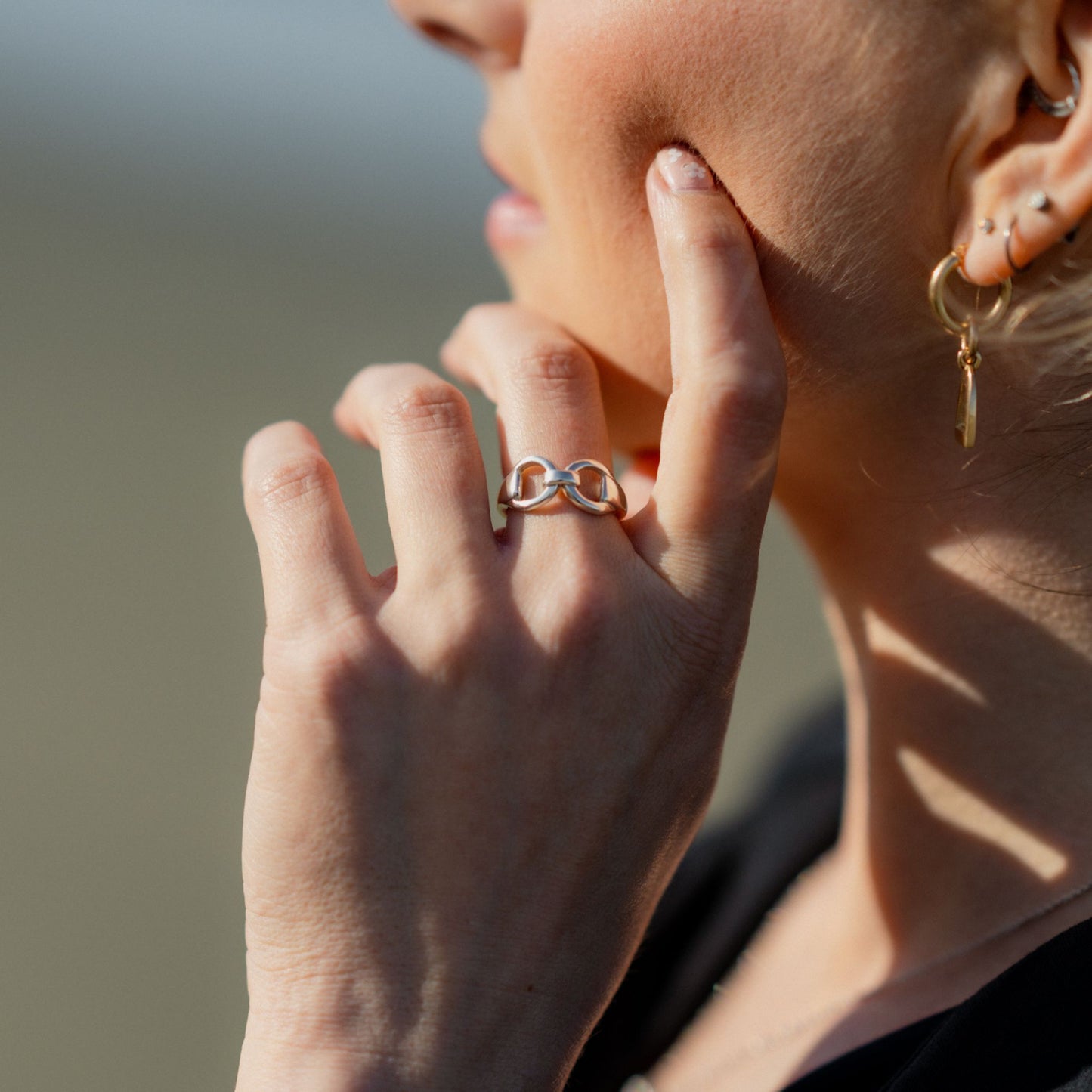 Horse rider with her hand touching her face, on her finger she is wearing a horse bit snaffle silver ring, made by Crawford Hill Equestrian Jewellery. 